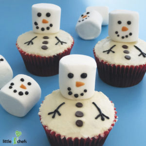 chocolate cupcakes with white frosting and marshmallows decorated to look like snowmen